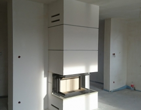 Nasze realizacje - Nowoczesne NR-N-233 - Nowoczesny kominek z wkładem trój-szybowym Hajduk. Obudowa prosta wykończenie wokół pieca z czarnego granitu, powyżej wkładu zabudowa podzielona 3 bonie dodające lekkości kominkowi. projekt kominka: Marcin Deręgowski